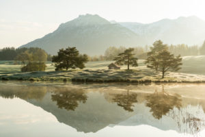 Goldenes Morgenlicht am Ufer des Schmalensee, mit Spiegelung des Karwendel und der Bäume am Ufer Goldenes Morgenlicht am Ufer des Schmalensee, mit Spiegelung des Karwendel und der Bäume am Ufer